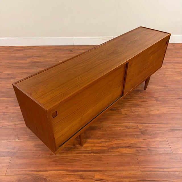 Gorgeous vintage teak sideboard by Niels Otto Moller for JL Moller, made in Denmark circa 1960's. This piece features...