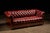 Antique leather sofa in a rich oxblood on turned, round oak feet. This item features leather nail heads within the tufts...