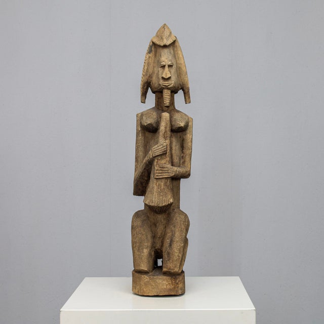 A striking hand-carved wooden sculpture inspired by the traditional artistic language of the dogon people of mali....