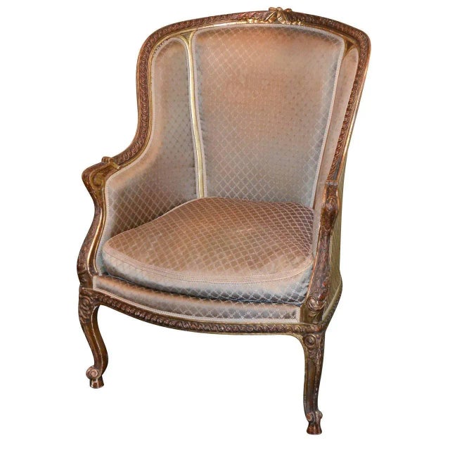 Fabulous 19th century French Louis XV style carved and upholstered bergere chair with antique gilt lacquered finish and a...