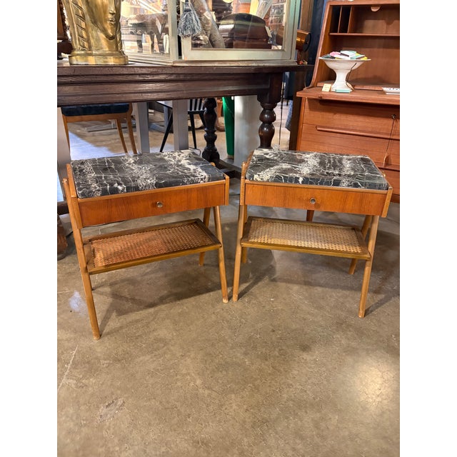 Gorgeous pair of 1960’s teak wood stands. Marble tops and small, elegant drawers. These have a slight movement to them and...
