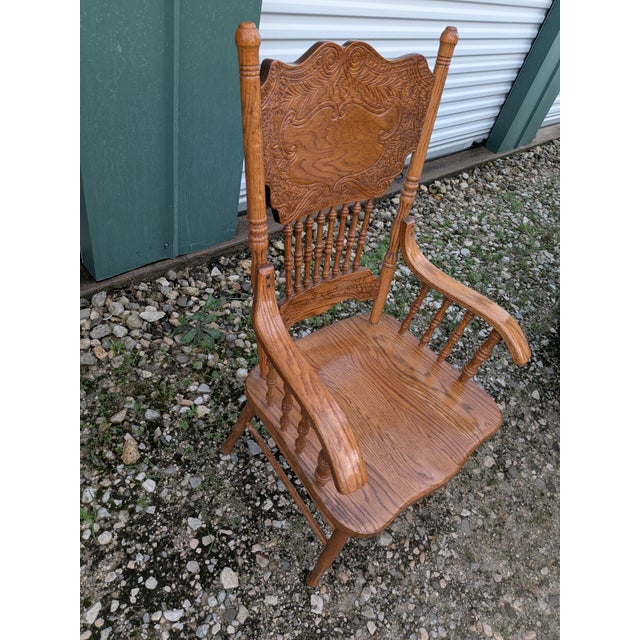 Mid-century press back arm chair with spindles featuring decorative scrollwork on the back rest. Sturdy chair. This chair...