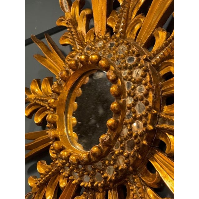 The Vintage Italian Carved and Giltwood Sunburst Mirror is a luxurious and ornate piece of home décor. With intricate...