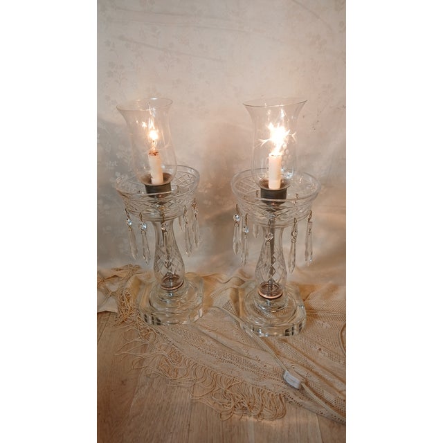 Elegant and complete matching pair of vintage mid-century Hollywood Regency style electric crystal hurricane lamps. Often...