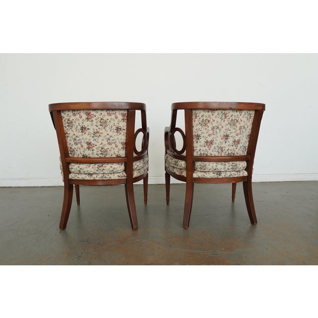 Vintage Neoclassical style open armchairs featuring gracefully curved arms with distinctive interlocking circular cutout...