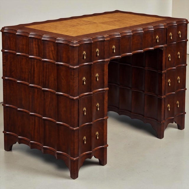 This is a petite Hollywood Regency era carved mahogany kneehole desk with a mottled faux tortoise finish. The most...