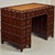 This is a petite Hollywood Regency era carved mahogany kneehole desk with a mottled faux tortoise finish. The most...