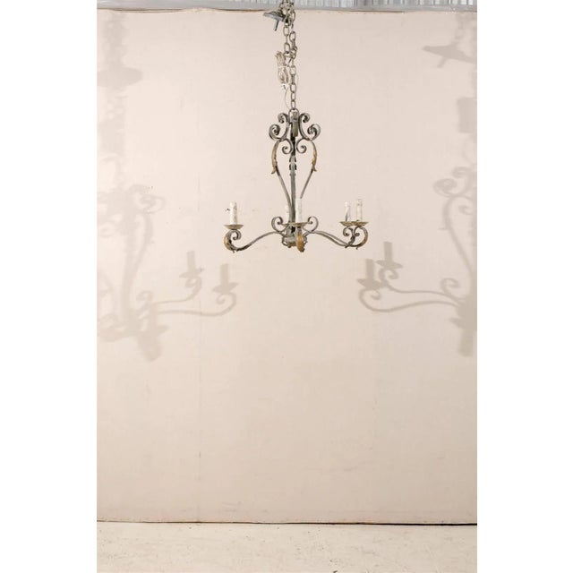 A French painted iron six-light chandelier with gilded acanthus leaves decor marking the end of the scrolled arms and...