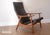 Handsome vintage mid century modern reclining lounge chair with teak wood and black vinyl. Upholstery shows parallel...