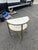 A refined two-tier accent table featuring elegant white marble surfaces framed in warm brass-toned metal. The unique...