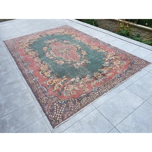 This is a vintage Turkish Oushak rug from the 1960s. The piece was hand-knotted