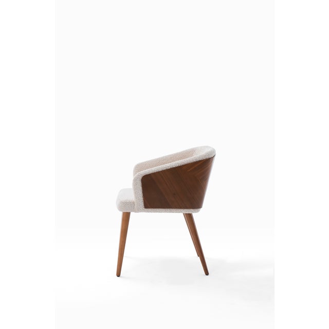 The Perla Dining Chair is a harmonious blend of natural texture and timeless design. Featuring a soft bouclé upholstered...