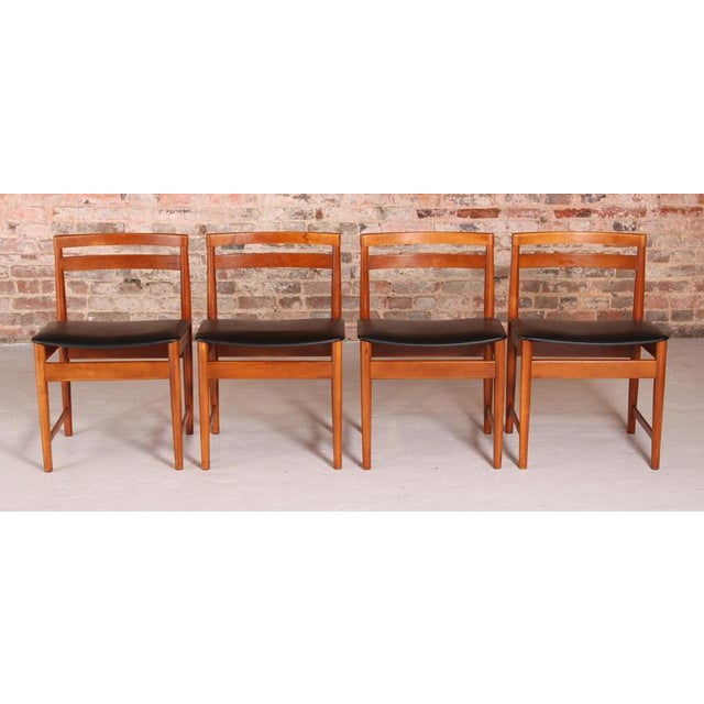 Set of 4 Mid Century teak chairs, circa 1970s. The original black vinyl upholstery in excellent condition. The frames have...
