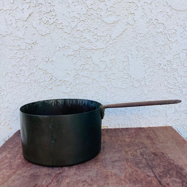 This is a great old antique copper saucepan with a riveted iron handle. From the mid 1800s, it is showing its age...
