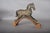Antique Indian folk-art horse, hand-carved in wood with an aged painted finish in black, red and gold tones. The standing...