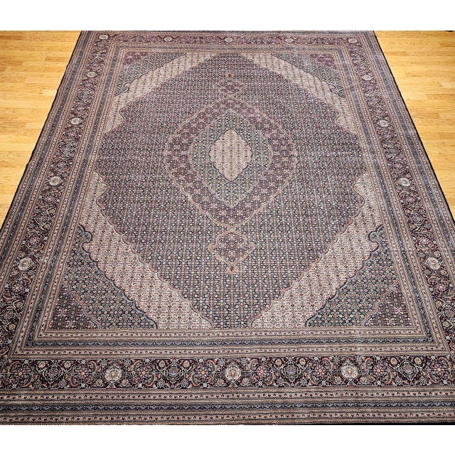 Exuding sophistication and exceptional craftsmanship, this near-square vintage Persian Tabriz Mahi rug is a rare find—both...
