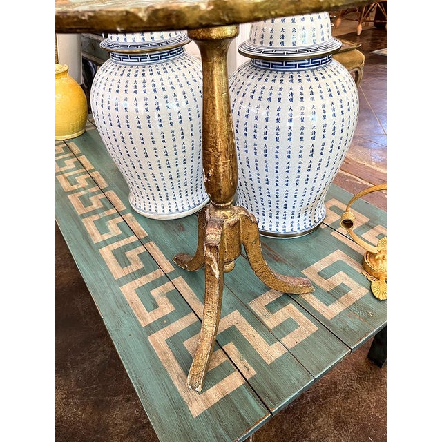 This table has three petite legs. It is painted turquoise and blue and is sturdy for its age and side.