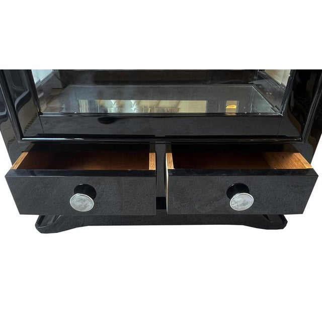 Art Deco showcase with three-sided glazing. France around 1930. Black painted wood with 3 glass shelves. 2 drawers....