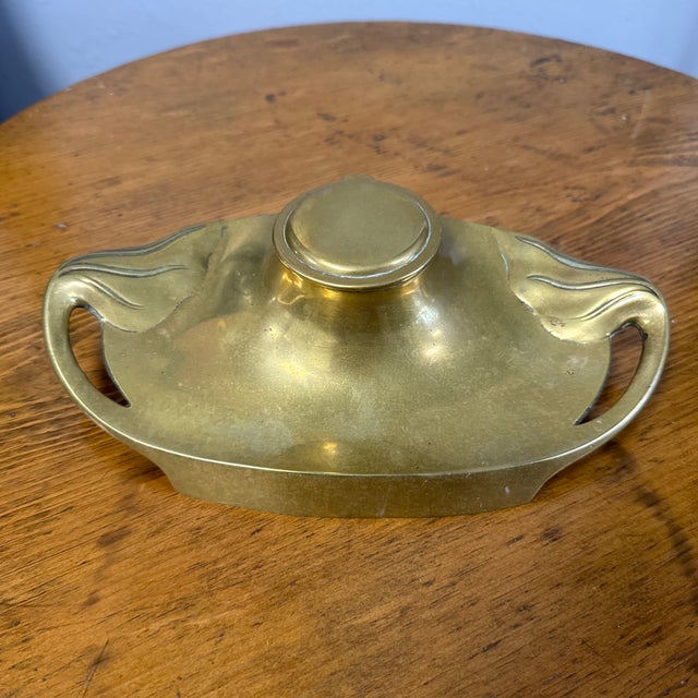 This exquisite antique brass inkwell, likely crafted in Germany and sourced from the UK, is a timeless piece that blends...