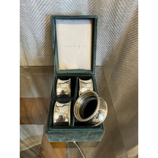 Set of four vintage silver plated new in box by Saks Fifth Avenue napkin rings.