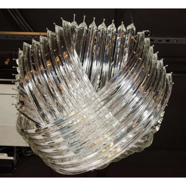 A gorgeous chandelier comprised of numerous curved, hand-blown Murano glass triedre shaped glass rods that are formed in...