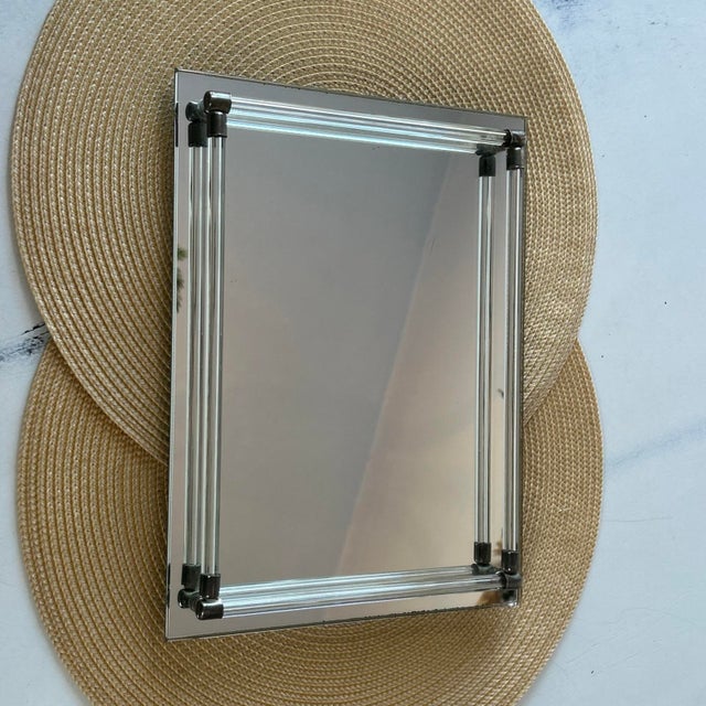 The vintage Mirrored Dresser Vanity Tray features a sleek design with lucite rails, brass accents with a footed bottom,...