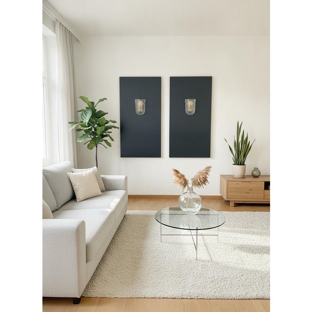Elegant pair of wall sconces featuring a distinctive Murano glass shade. The sconce has an elongated oval shape, mounted...