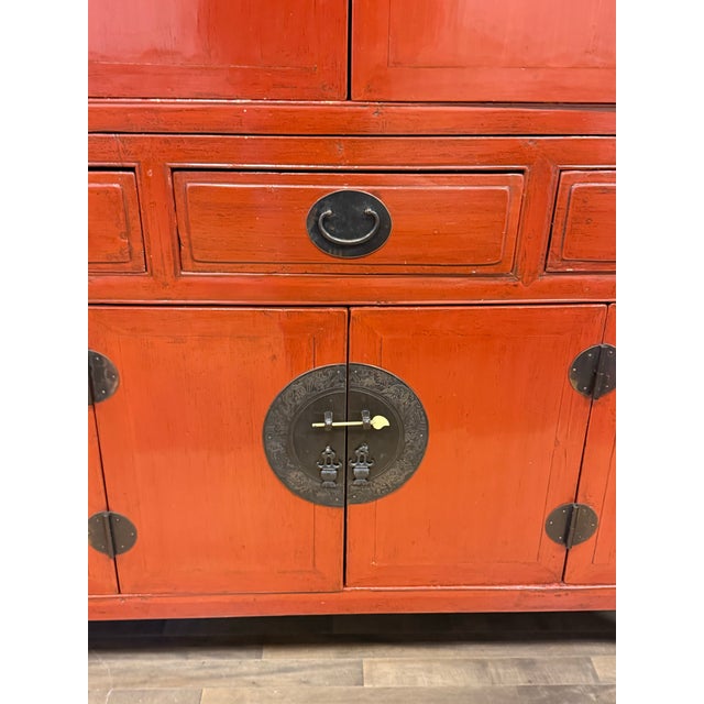 Design Plus Gallery presents a Two Piece Vintage Asian The cabinet is lacquered in a china red color with dark brass...
