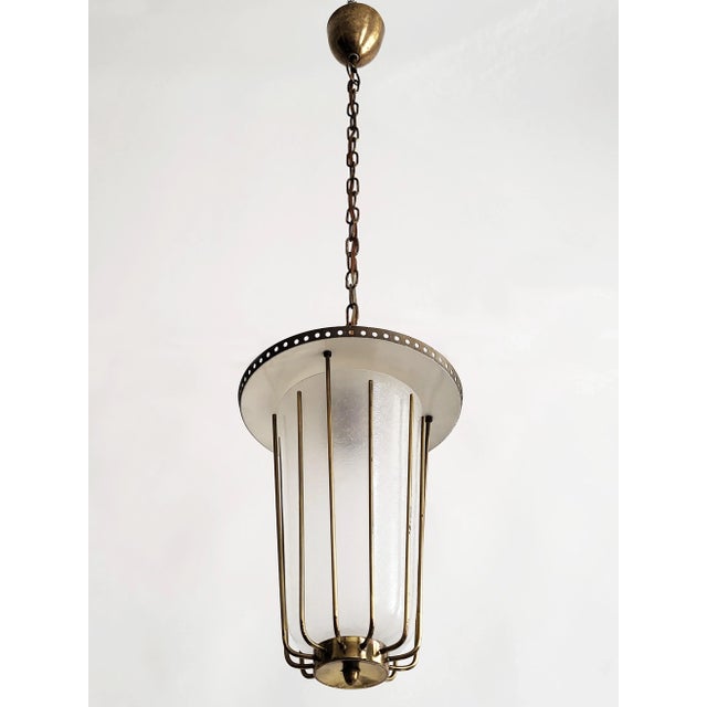 Elegant Austrian modernist design pendant light made of brass with a beautifully structured mid-century glass shade in the...