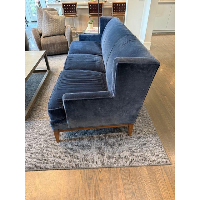 The Tasha wingback sofa by Mitchell Gold + Bob Williams in blue velvet with tapered wood legs and frame. This modern...