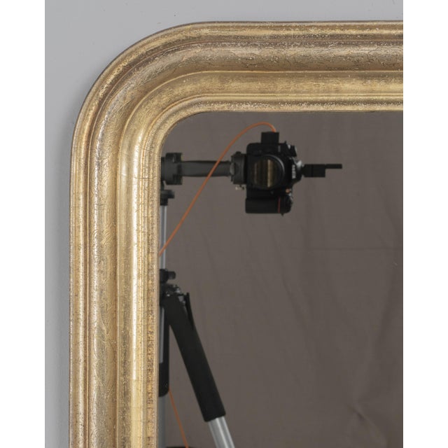 An early 20th century French Louis Philippe style mirror with curved top corners, incised floral decoration and bright...