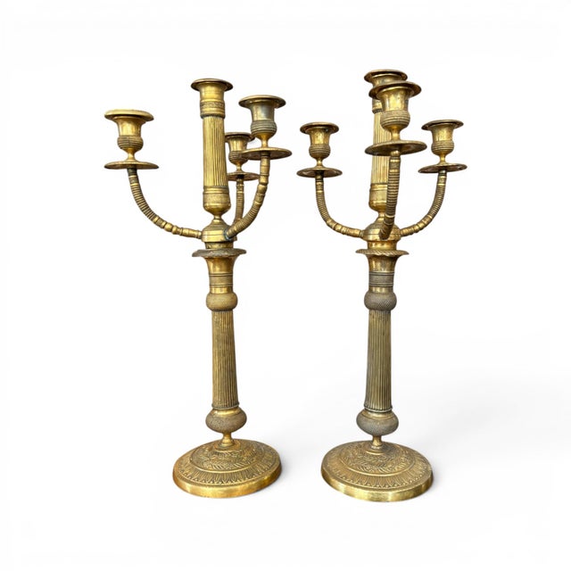 An elegant pair of early 20th-century brass candelabras featuring classic proportions and a beautifully aged patina....