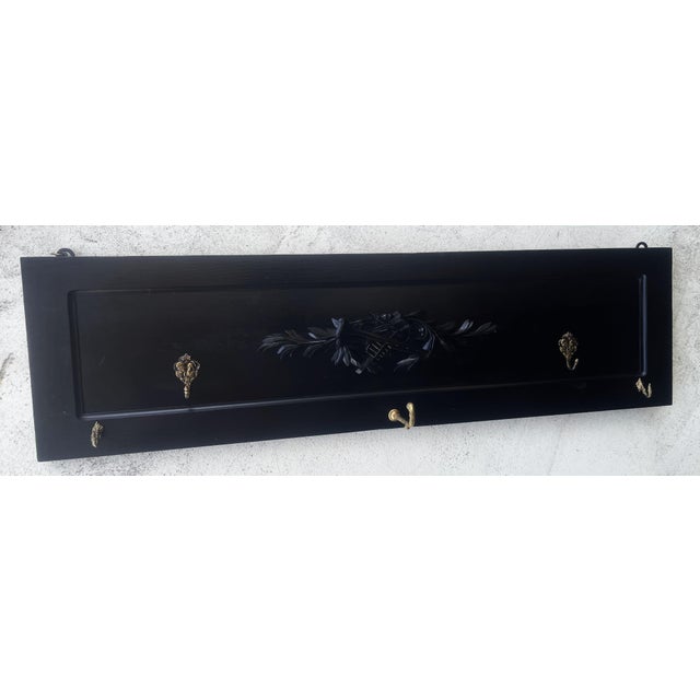 Black 19th-century wall coat rack made of solid walnut with a carved decorative panel This wall coat rack is made of solid...