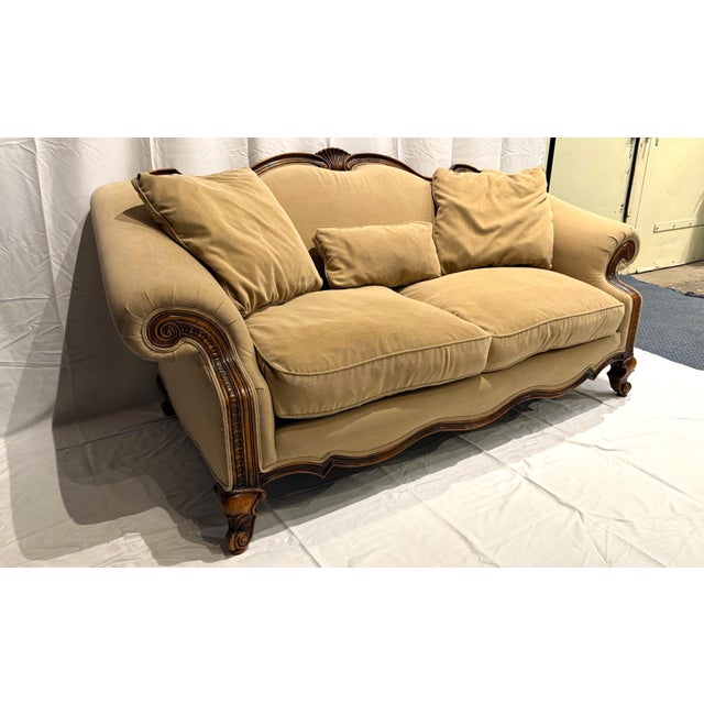 An elegant sofa with durable taupe-colored upholstery. The detailed carved wood details make it stand out. It has been...