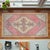 Authentic hand-knotted accent mat in soft sun-faded coral and pale yellow tones — perfect for entryways or bedside spaces....