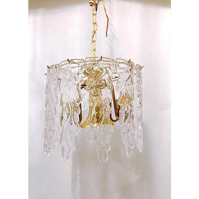 This is a vintage Murano chandelier with decorative triangular panels and gold plated frame. This light has 7 candelabra...