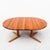 A solid teak split pedestal base dining table with two leaf extensions, made in Denmark by Juul Kristiansen in 1983. At...