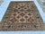 This beautiful hand-knotted wool area rug features a classic Afghan Kazak tribal style. The center field has a warm grey...