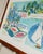 Fall in Love with the vibrant beach motif captured in this stunning vintage lithography by Enrico Paolucci, a celebrated...