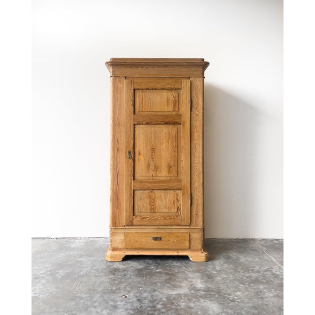 Late 19th c. antique European pine knockdown wardrobe featuring a single paneled door, original garment hooks inside, one...