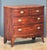 A handsome English bow-front chest of drawers of mahogany in the Georgian style, featuring a bowed top with a beautiful...