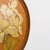 An exquisite pair of circular/oval red terracotta plaques, hand-painted with highly realistic botanical depictions. One...