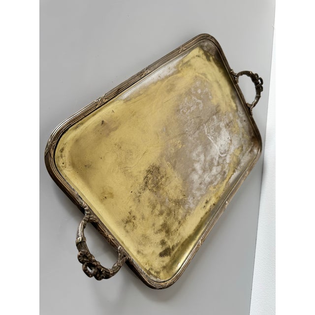 This elegant vintage silver-plated serving tray features a rectangular shape with beautifully crafted ornate handles. The...