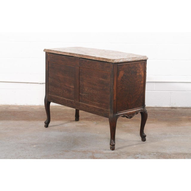 An elegant French Louis XV style commode, with richly figured burl veneers, original marble top and brass hardware, from...