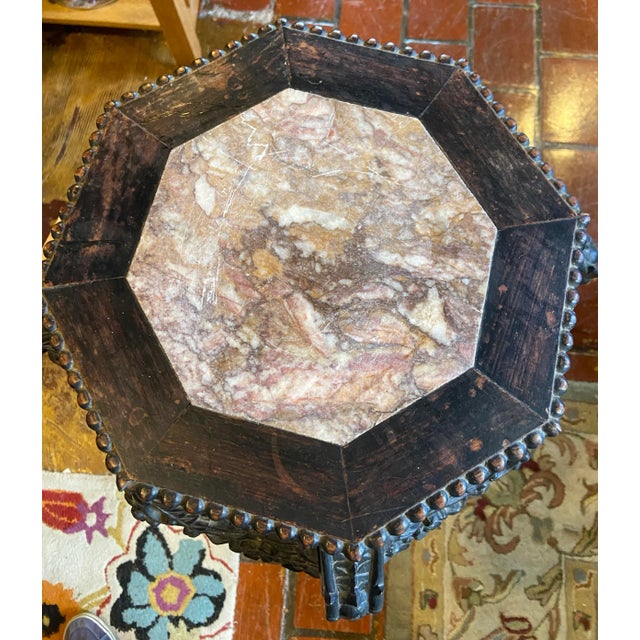 Octagonal teakwood stand with pierce carved apron and inset marble top. Features cabriole legs with stretchers intricately...