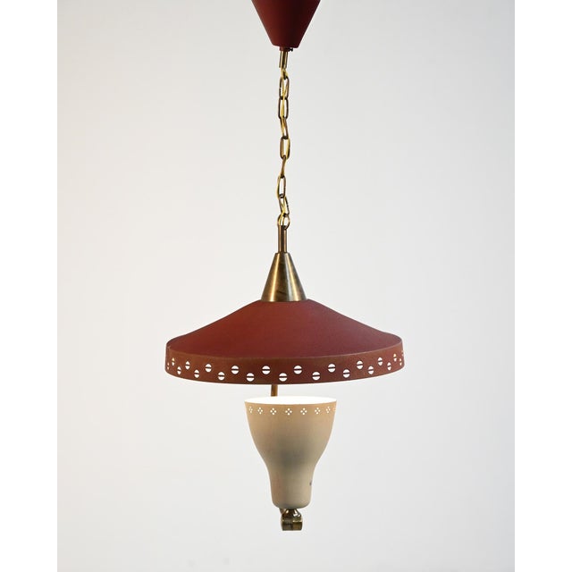 Pendant lamp in lacquered metal and brass with a double perforated shade and an adjustable curved arm, made in Sweden in...