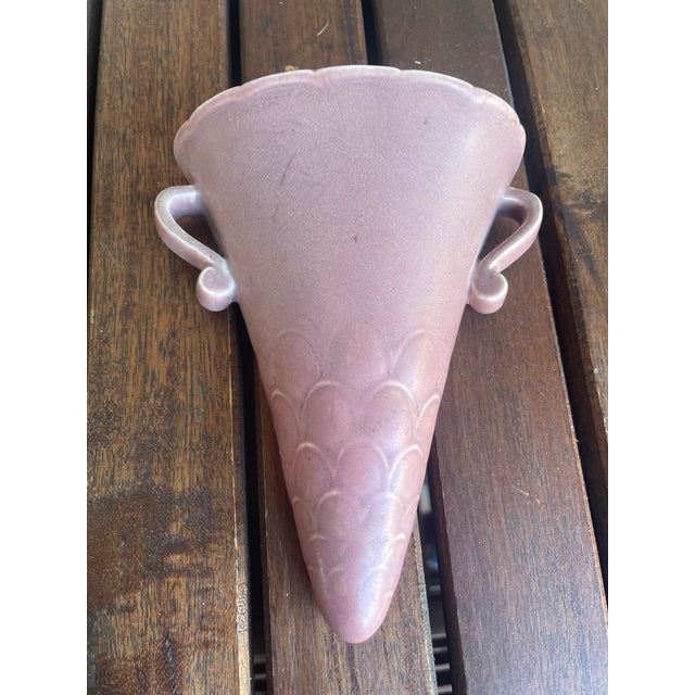 This wall vase, or wall pocket, is from Rookwood Pottery of Cincinnati, Ohio. The marking on the back indicates a date of...