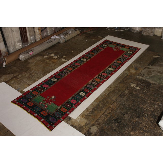Handmade with hand-knotted wool originating circa 1950-1960, this mid-century rug connotes a distinctive, vintage arts &...