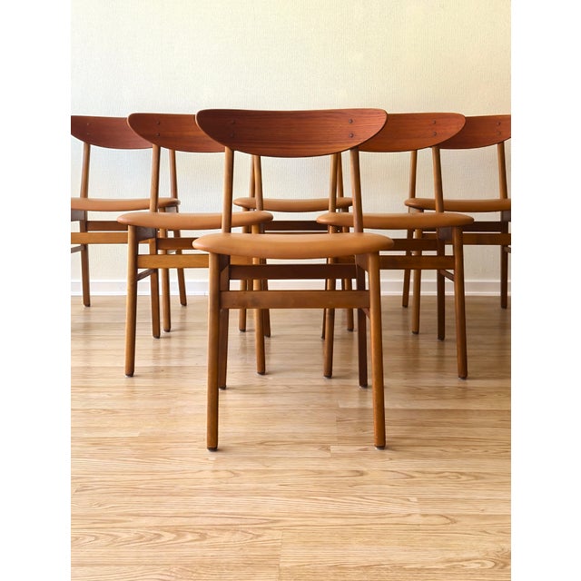 A beautifully restored set of six Danish Farstrup Model 210 dining chairs, crafted in solid beech with sculptural teak...