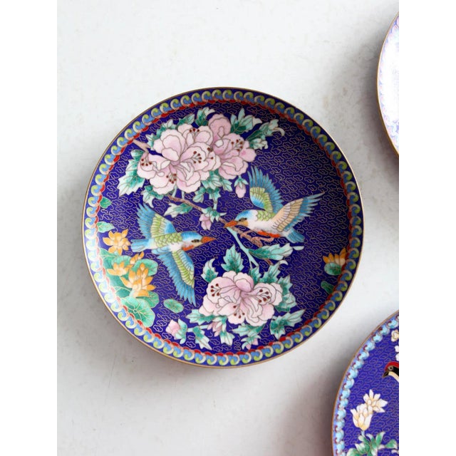 A collection of three vintage cloisonné plates from The Ching-t’ai Ian Artist Workshop. Each plate showcases a stunning...